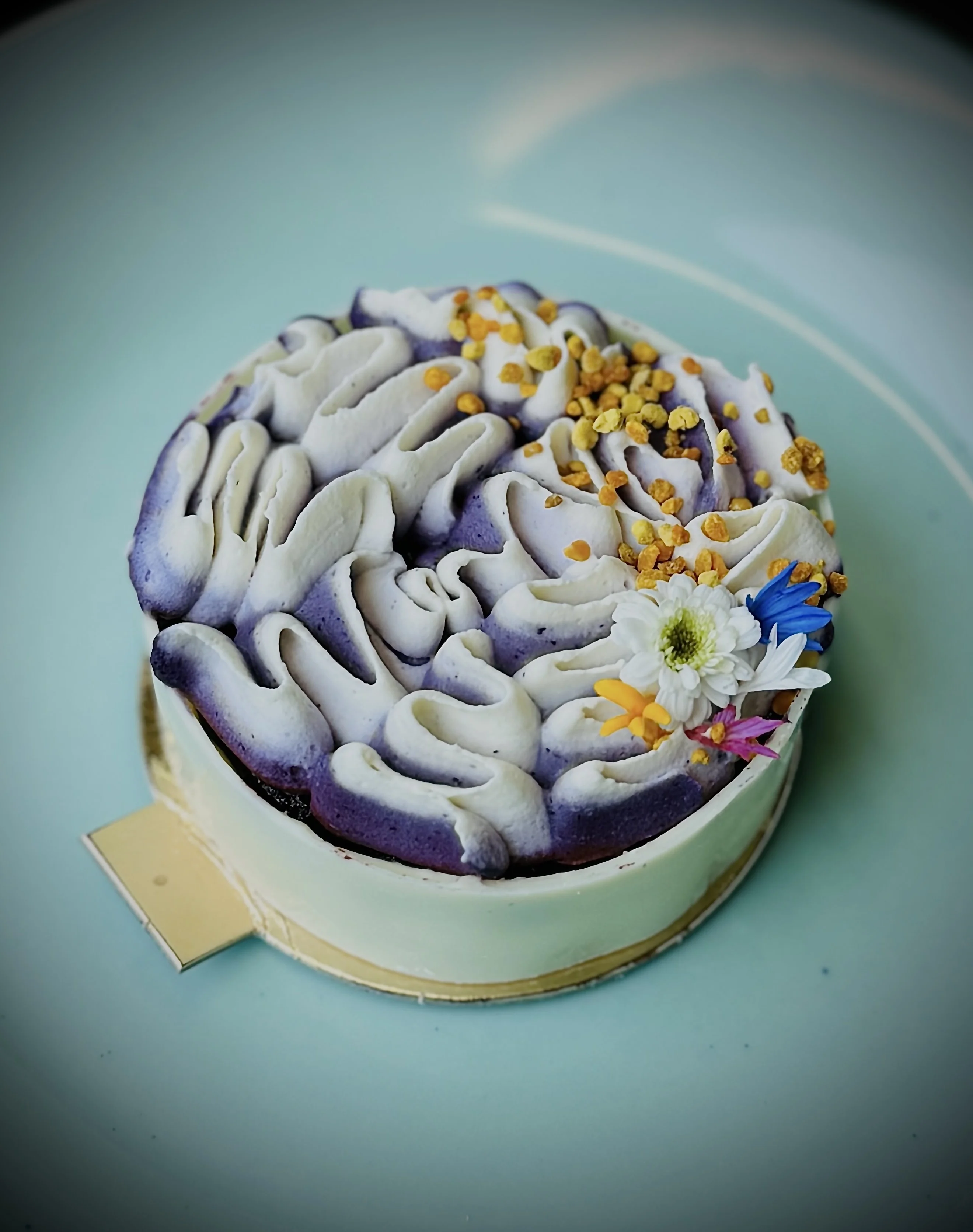 Ube, Honey & Bee Pollen — purple-yam crown over white-chocolate ganache finished with bee pollen and edible flora